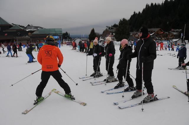 instructor dando primeras indicaciones a alumnos con sus 2 esquís puestos